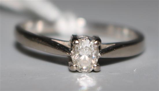 A modern 18ct white gold and oval cut solitaire diamond ring, size Q.